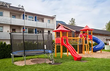 Der Spielplatz im Garten mit Trampolin und Turm